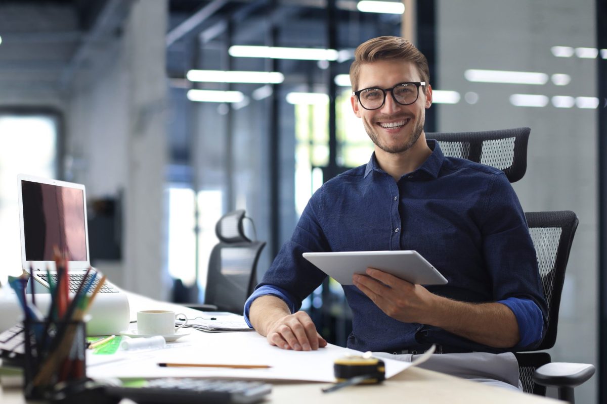 Young,Modern,Business,Man,Working,Using,Digital,Tablet,While,Sitting